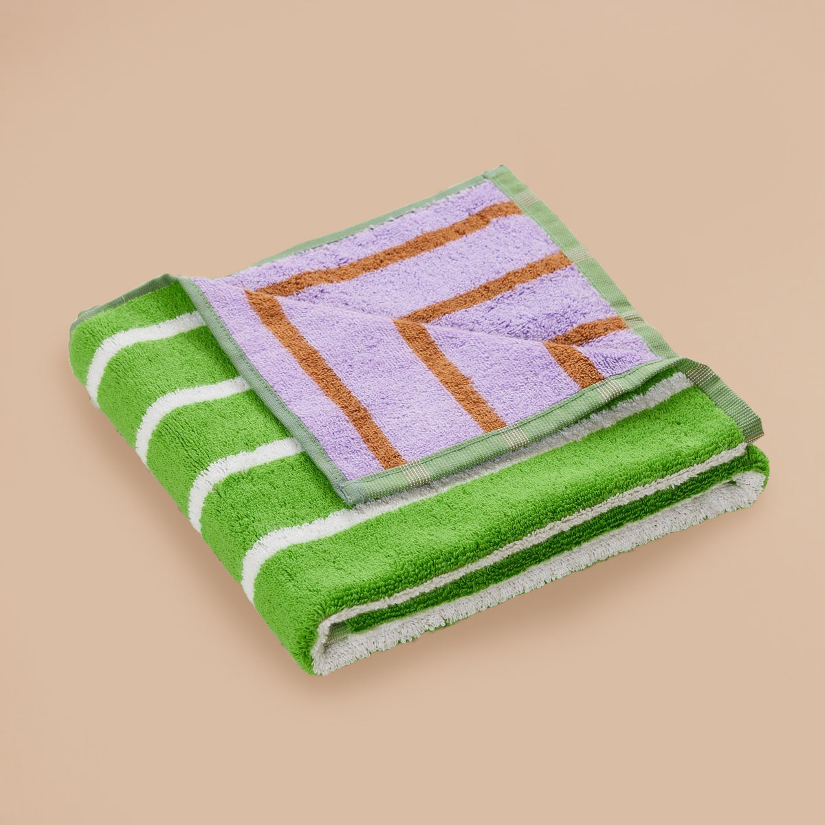 Glass Stripe Hand Towel by Dusen Dusen – folded towel featuring green with white stripes and lavender with brown stripes, displayed on a beige background.