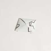 Back view of the pépite origami-style gift card in its folded form, showcasing a clean and minimalist design with crayon-style black details.