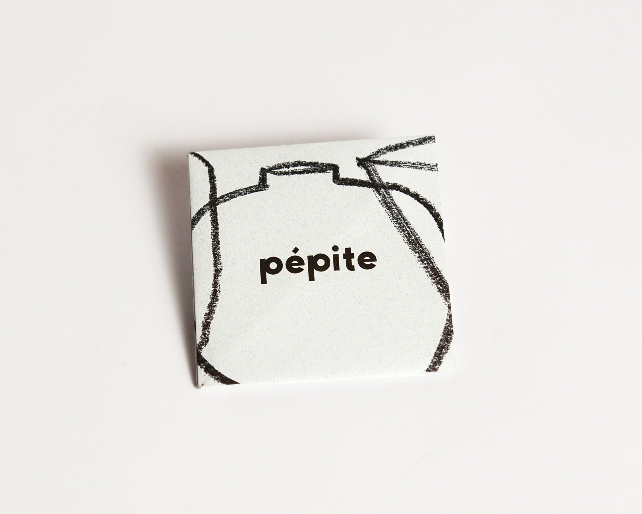 pépite origami-style gift card in its folded form, featuring a minimalist design with a black crayon-style graphic and 'pépite' logo on the front.