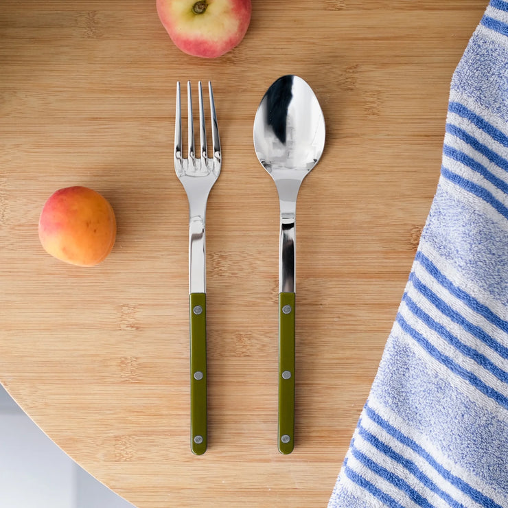 Sabre Paris 2-piece serving cutlery set in Green Fern displayed on a wooden surface with apricots and a striped towel, showcasing its elegant design and polished stainless steel.