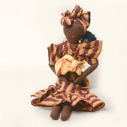 Imani doll by SilaiWali sitting upright, wearing a colourful headscarf and dress, made from recycled materials.