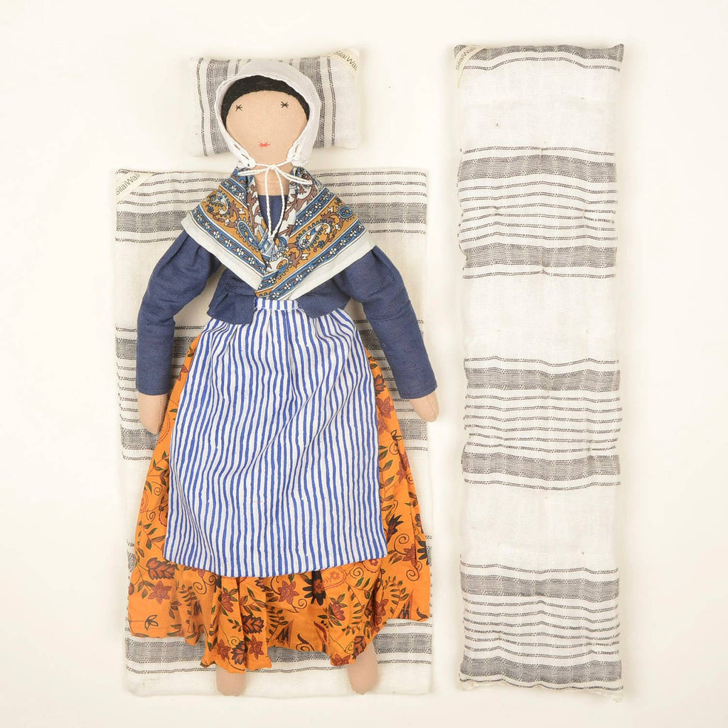 Jeanne doll by SilaiWali displayed with its bedding set, featuring striped fabric and bold dress details.
