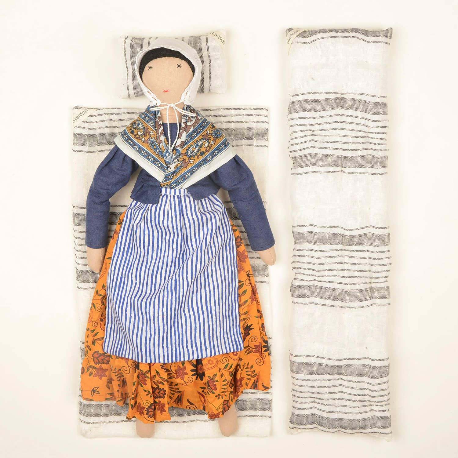 Jeanne doll by SilaiWali displayed with its bedding set, featuring striped fabric and bold dress details.