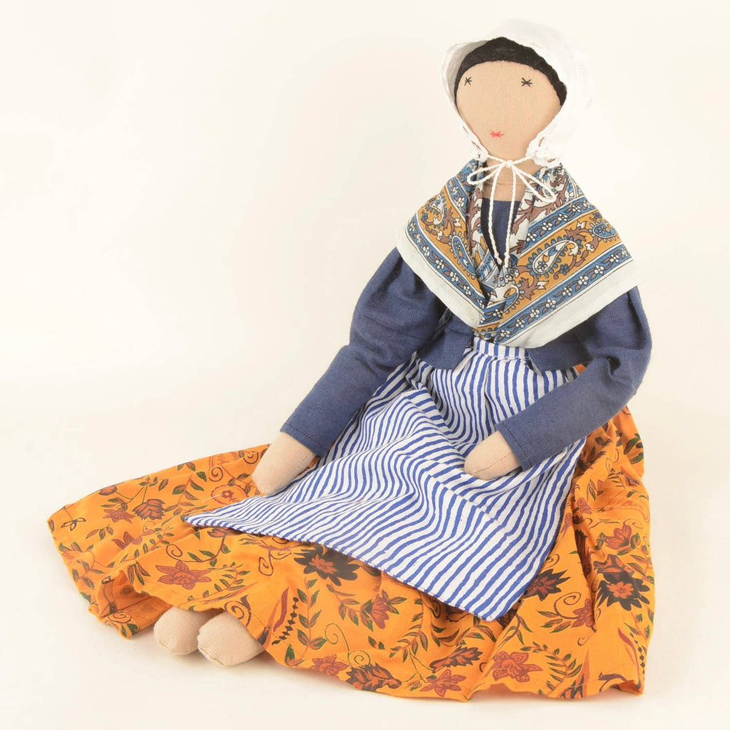 Jeanne doll by SilaiWali sitting upright, showcasing her patterned dress and sustainable craftsmanship.