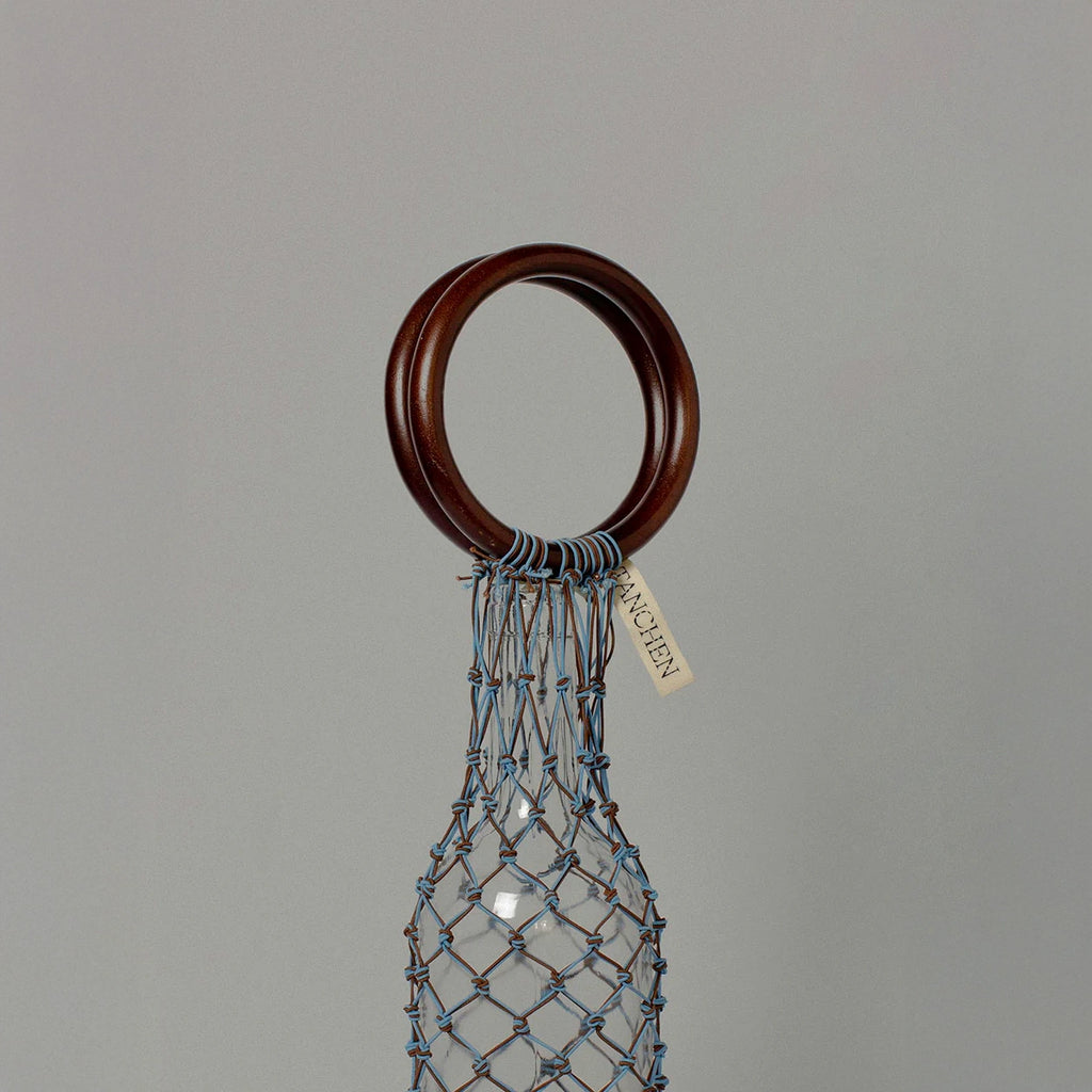 Close-up detail shot of the 00 Bag in Blue Brown by Tanchen, highlighting the craftsmanship of the woven netting and branded tag.