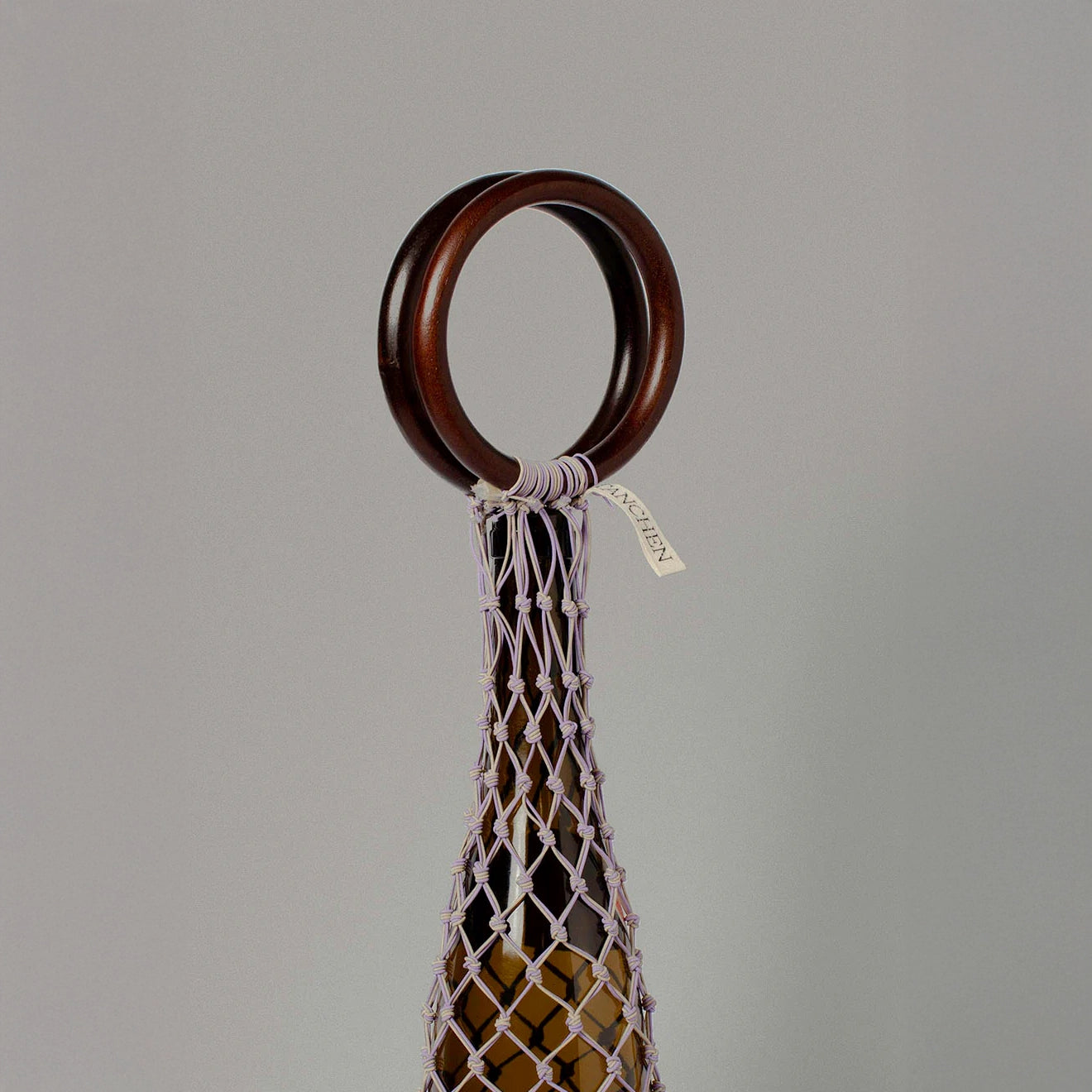 Close-up of the Tanchen 0/0 Bag in Lilac Sand with wooden ring detail and netting pattern.