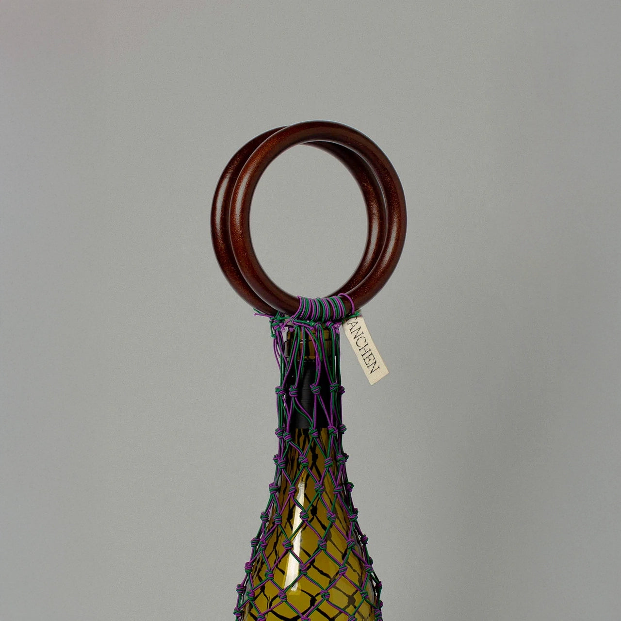 Close-up detail shot of the 0/0 Bag in Purple Green by Tanchen, showcasing the intricate purple and green netting and branded tag.