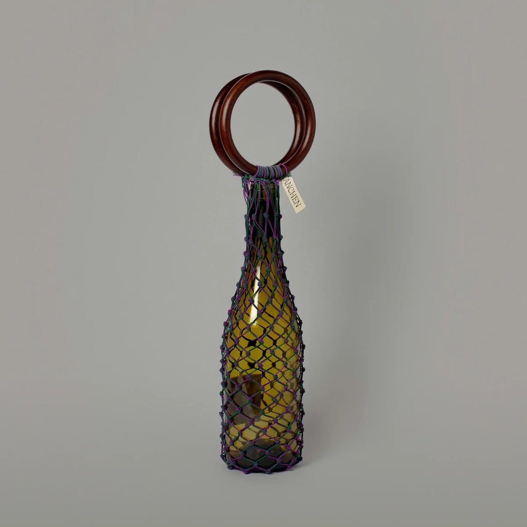 Front view of the 0/0 Bag in Purple Green by Tanchen, featuring a vibrant purple and green netting design with a wooden ring handle.