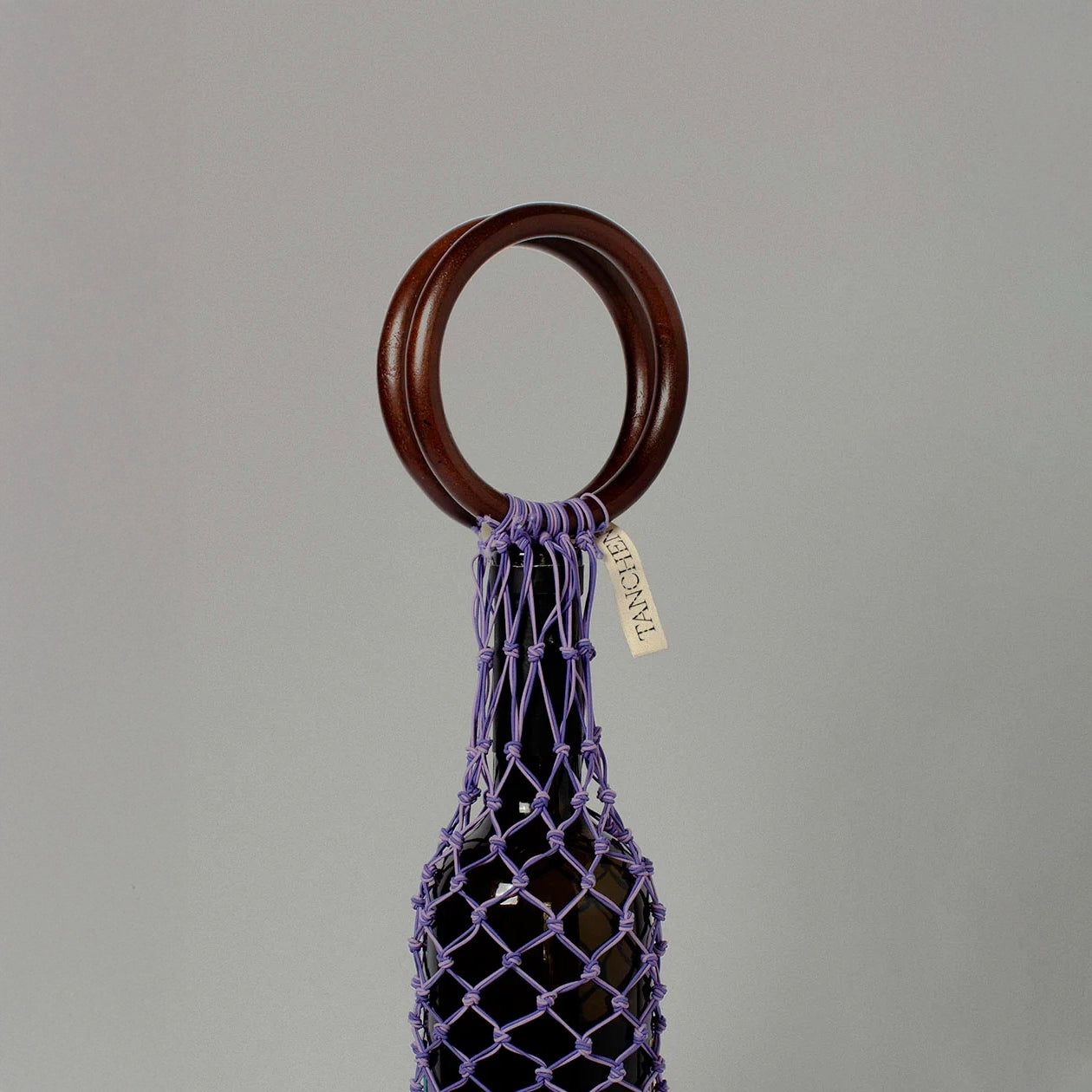 Close-up detail shot of the 0/0 Bag in Purple Lilac by Tanchen, highlighting the fine craftsmanship of the netting and the branded tag on the wooden handle.