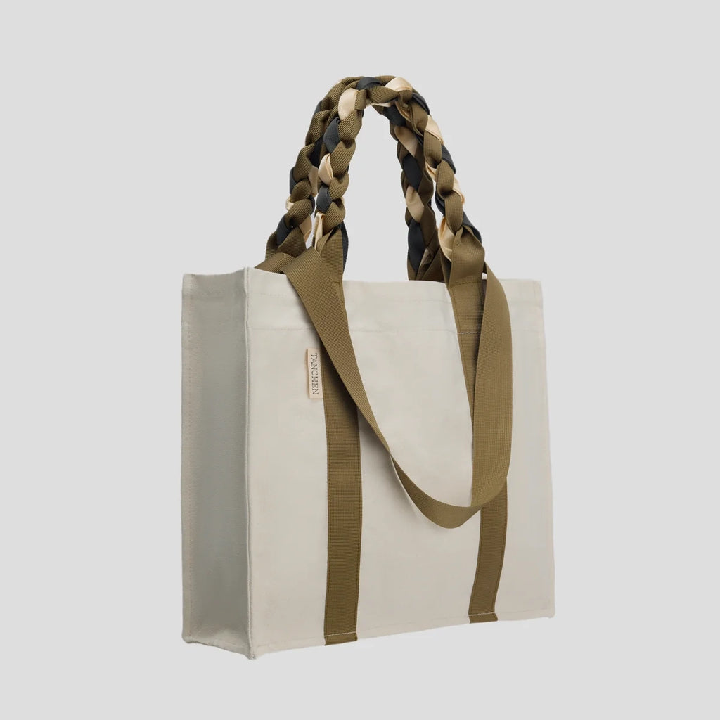 Side view of the Cream and Tan Picnic Bag Fizz! by Tanchen, highlighting its spacious design and sturdy braided handles.