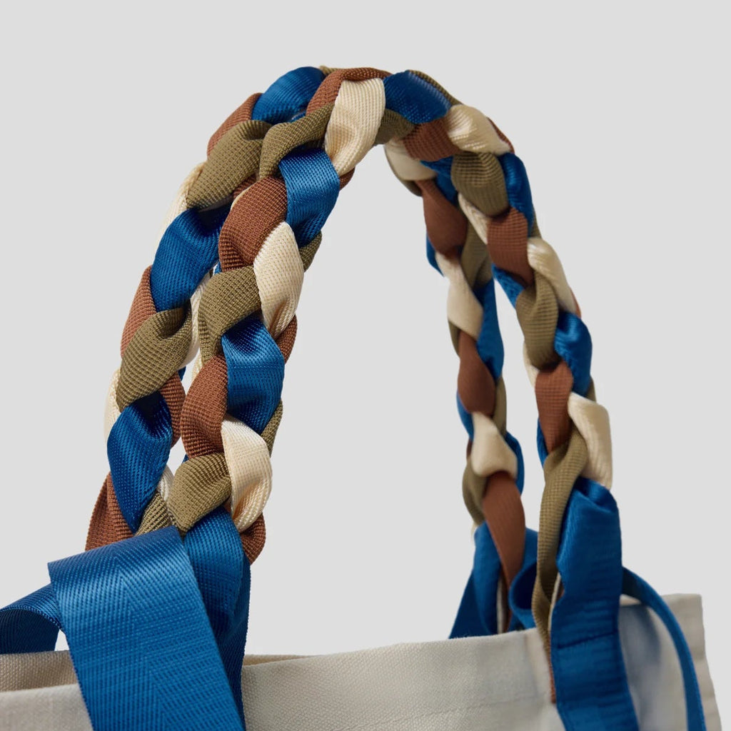 Close-up of the braided blue, brown, and cream nylon ribbon handles of the Picnic Bag Glou! by Tanchen, showcasing its elegant craftsmanship.