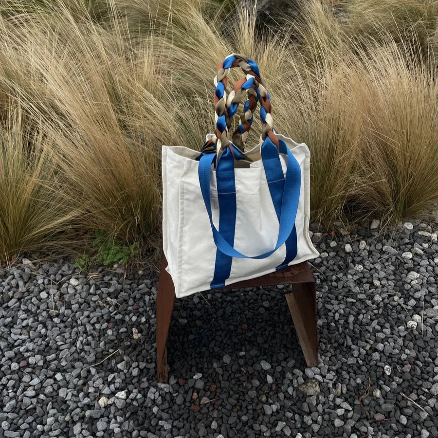 Outdoor view of the Picnic Bag Glou! by Tanchen, styled on a chair in a natural setting to highlight its versatility.