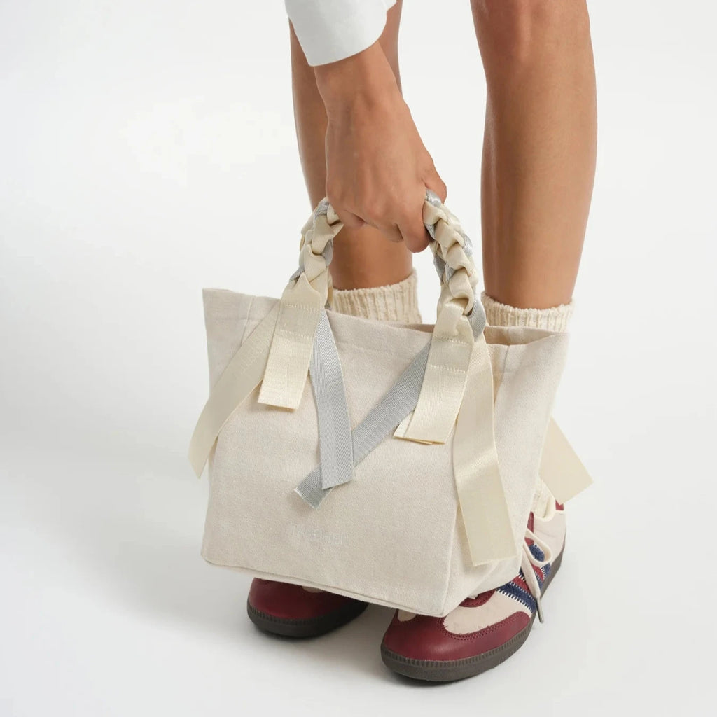 Close-up of the Picnic Bag Mini Soda in cream and silver by Tanchen, emphasising the braided handle and silver ribbon detailing. The high-quality stitching and materials are highlighted in this detailed shot.