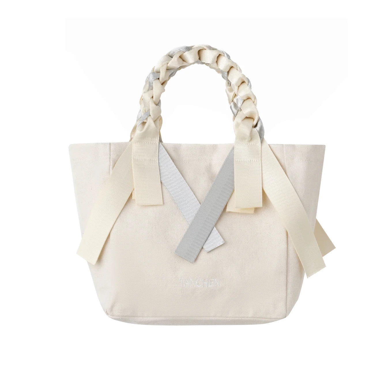 Front view of the Tanchen Picnic Bag Mini Soda in cream and silver, showcasing its cotton canvas body with silver nylon ribbon accents. The braided handle is visible, adding a unique texture to the design.